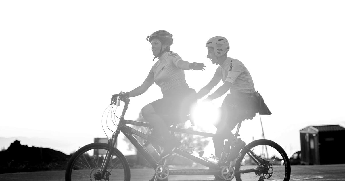 Pareja montando en bicicleta tándem, en blanco y negro