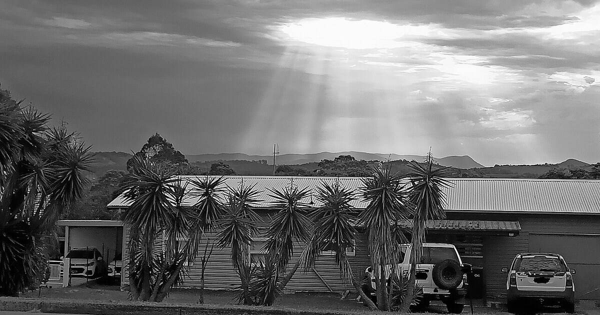 Casa de un barrio de Australia bajo un cielo de tormenta, en blanco y negro
